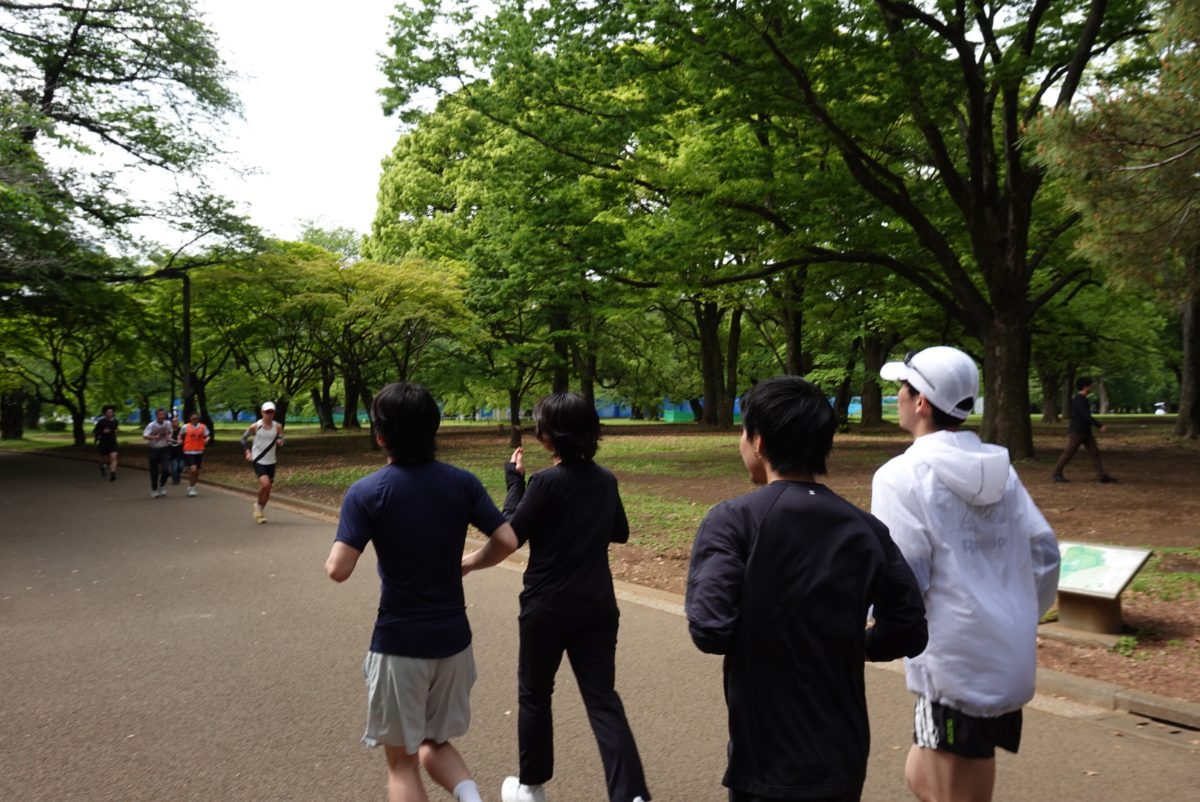 公園の並木道を一緒に走るランナー